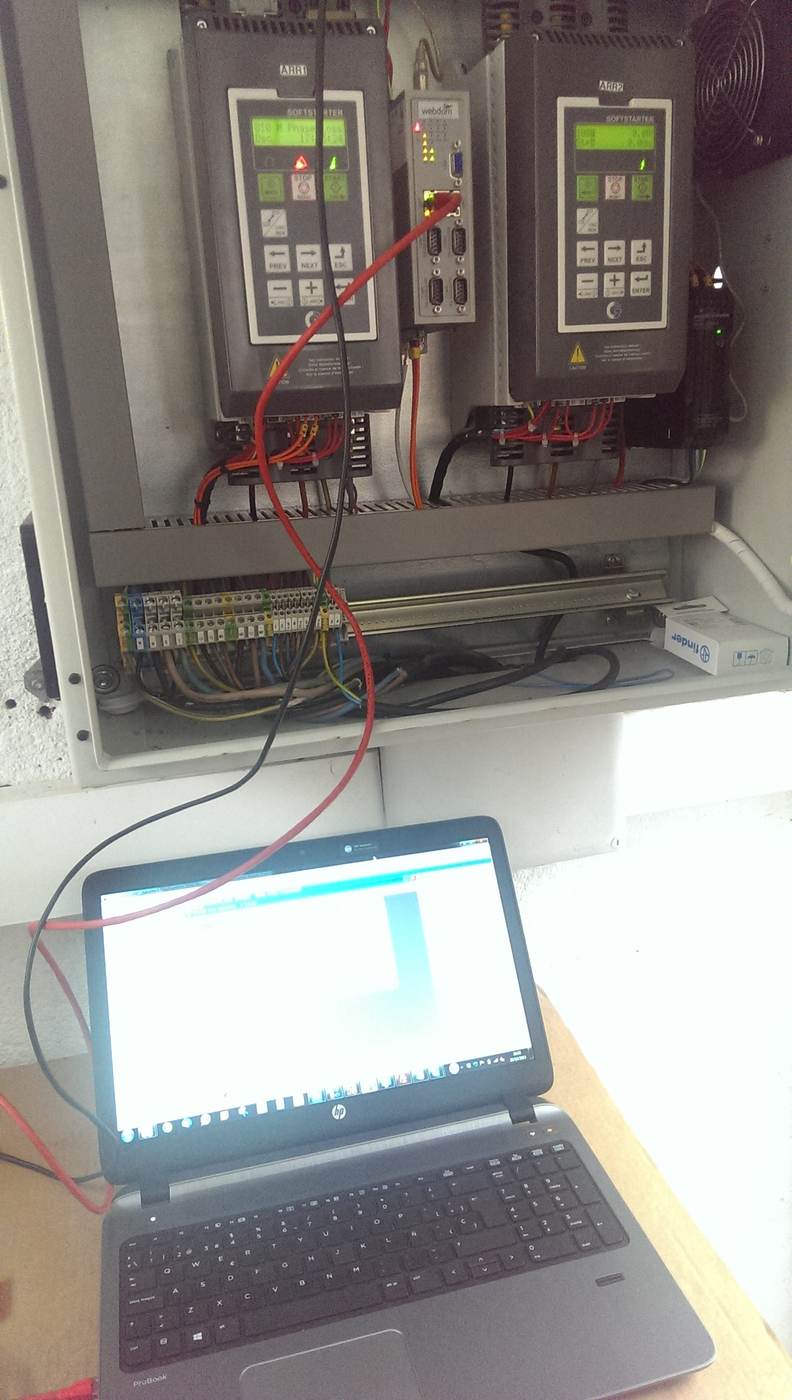 Técnico midiendo con un portátil en un cuadro eléctrico