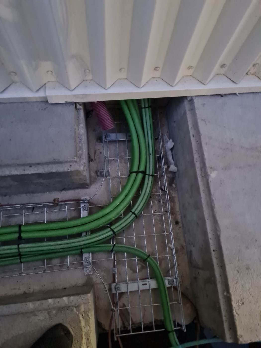 Cables de potencia sobre bandeja metálica bajo una plataforma
